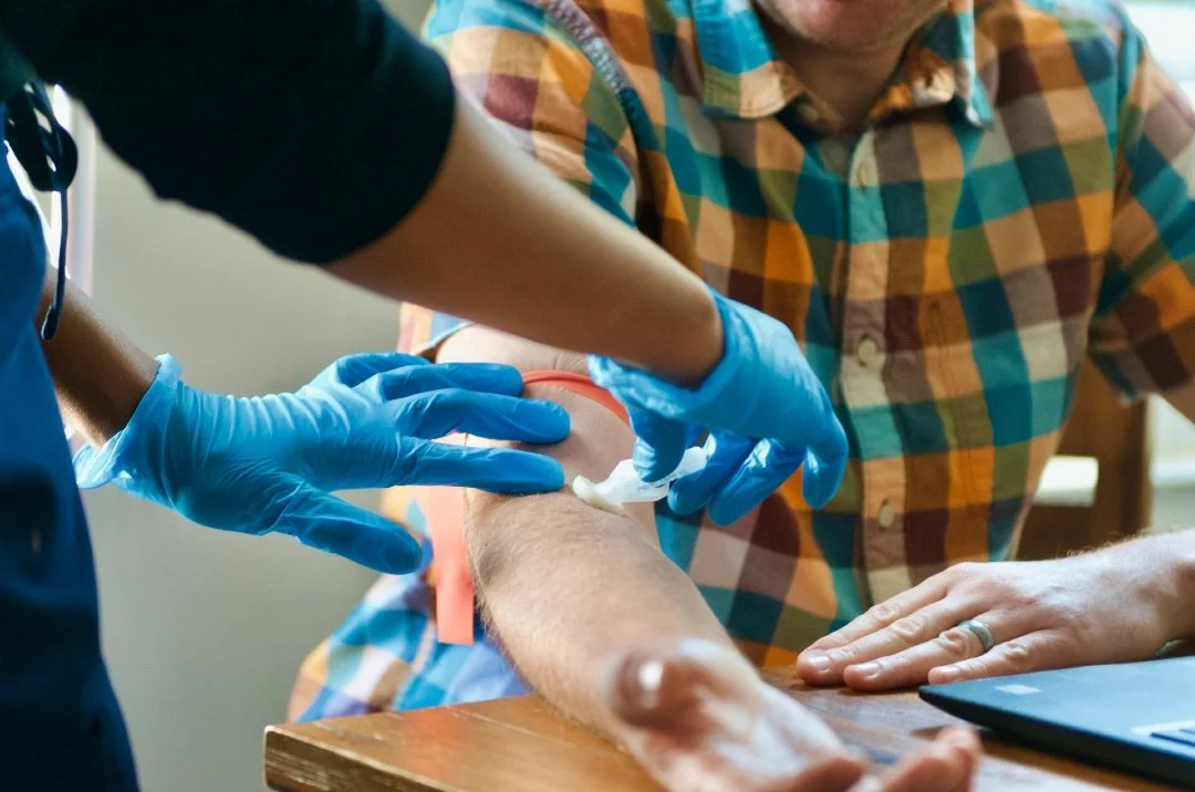 A nurse preparing a client's arm for an infusion